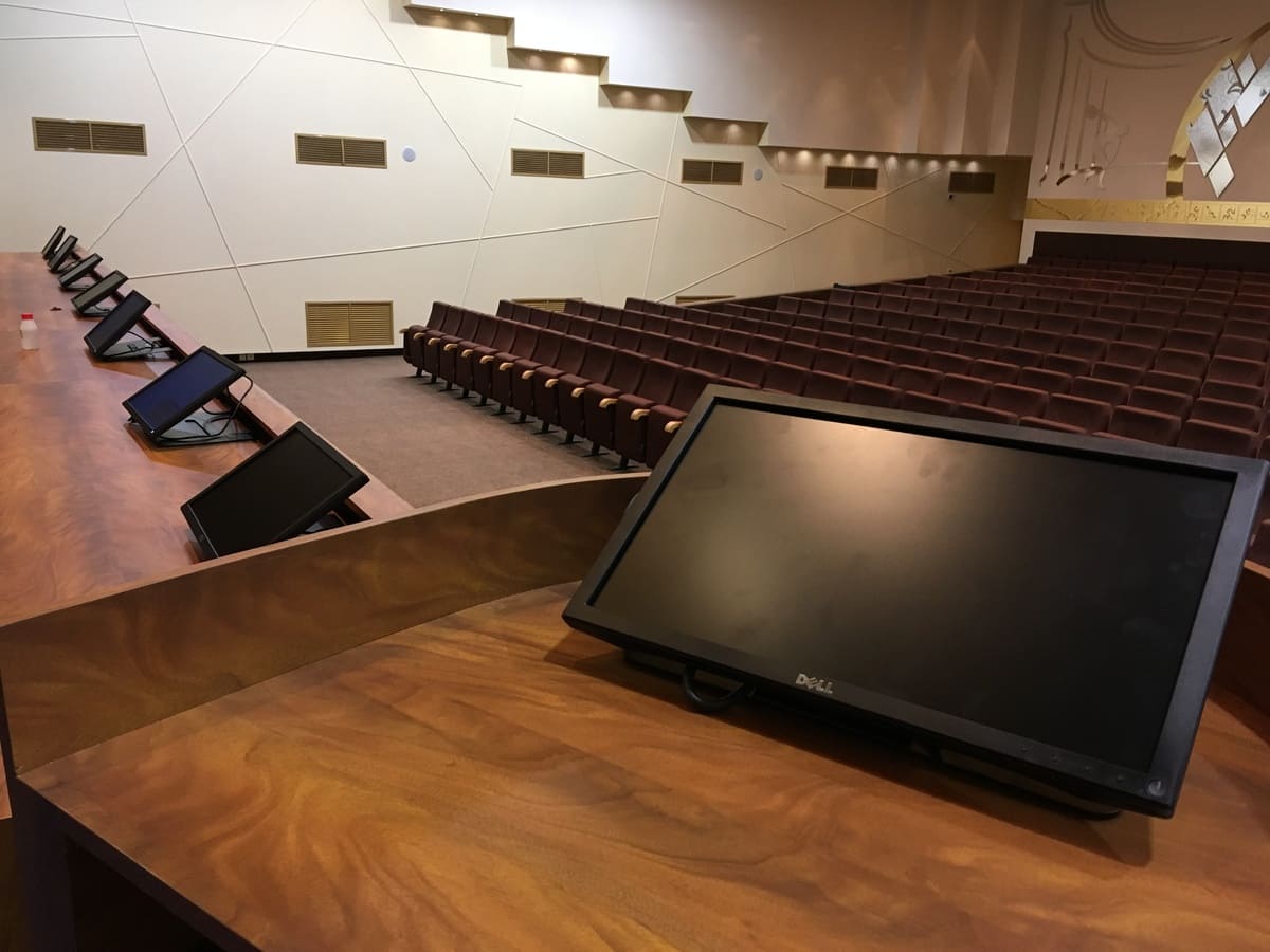 Было произведено проектирование аппаратного стола управления и стола для президиума, согласованы эскизные проекты. Была произведена полная перепрокладка сигнальной и силовой коммутации к новому аппартному столу и проложены новые кабели к сцене. Был смонтирован новый аппаратный стол и произведено его подключение. Был смонтирован стол президиума и произведено его подключение. Произведена окончательная наладка и запуск установленной AV-системы.