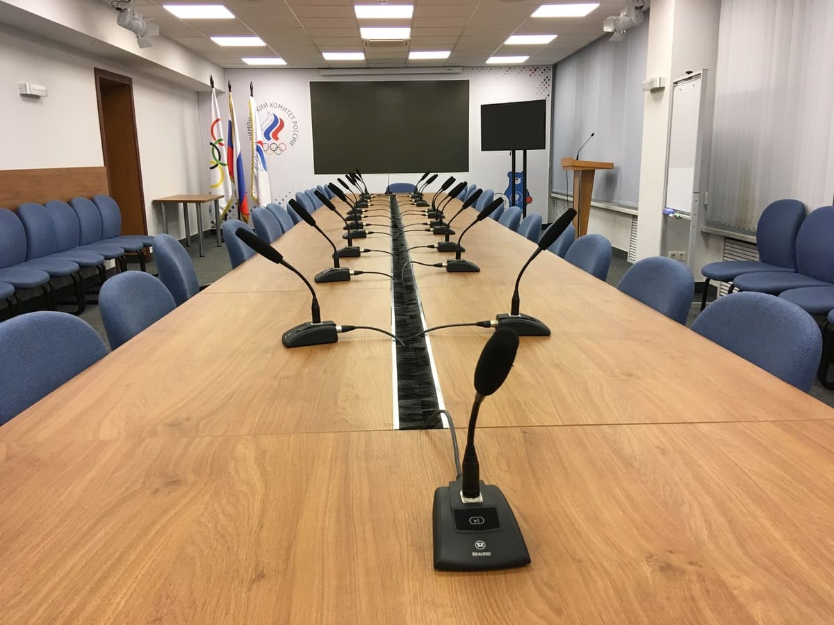 Комплексно обновить конференц-систему зала совещаний президиума ОКР. Улучшить систему освещения зала и сделать выделенную подсветку фирменного фотографического фона.